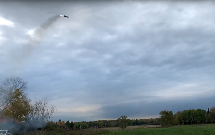 AirShare's Guided Missile flying in the sky over a large field as dusk.