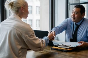 A handshake is made across the table. 