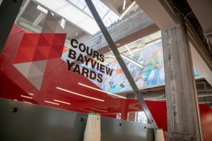 A mural showcasing the name and logo of Cours Bayview Yards. 